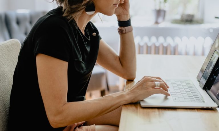 a woman sitting at a table with a laptop